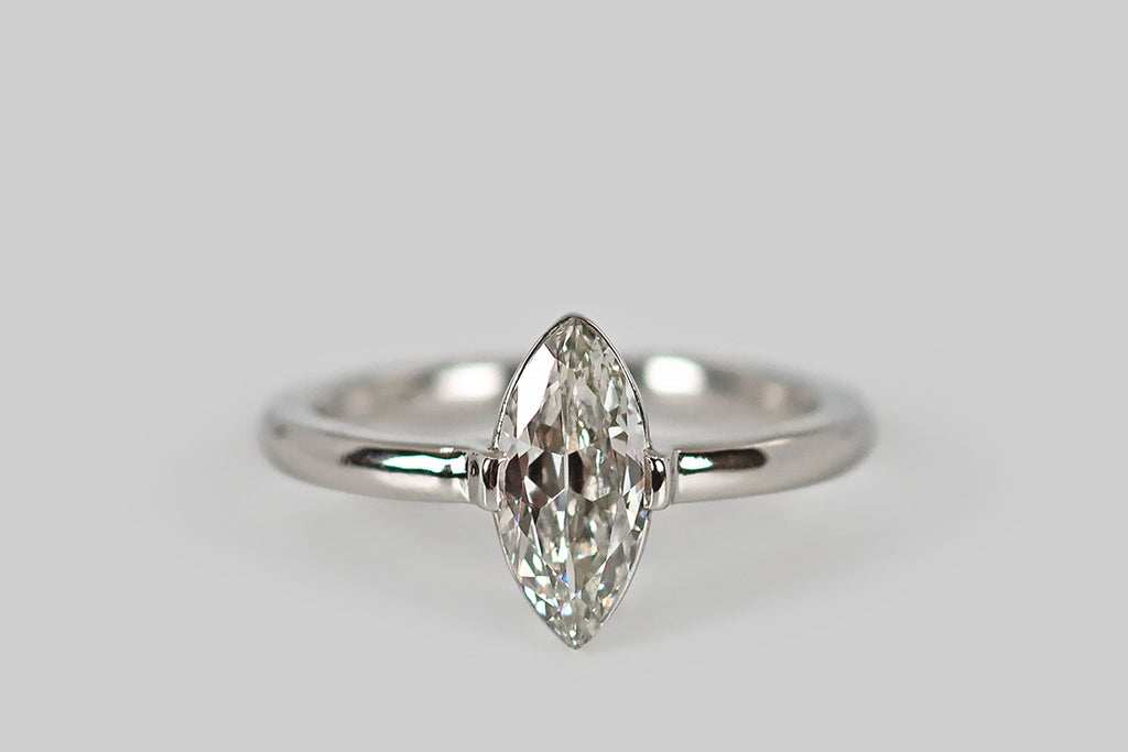 Antique Jewelry Portland, Vintage Jewelry Portland , Antique Engagement Rings | Poor Mouchette | Crisp and ethereal, an antique, .95 carat marquise-cut diamond (G/H, VS2) rests atop a polished, slim-line, platinum basket. This basket is bezel-like, with an extra-fine edge that allows the diamond to "float" on the hand. A pair of broad, low-profile, tab-style prongs hold the diamond securely at the east and west. 