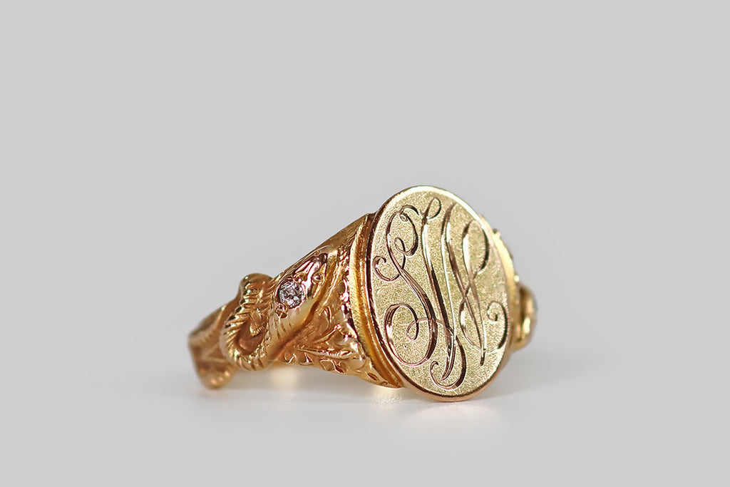 Antique Jewelry Portland, Vintage Jewelry Portland , Antique Engagement Rings | Poor Mouchette | An Art Nouveau era signet ring, modeled in 14k yellow gold, featuring beautifully-carved, naturalistic snake decor. This sinuous pair of snakes rest (one per side) one the ring's tapering shoulders— they are cast in high relief, so that they stand out from the oak leaves that lie beneath them. These snakes have been made to slither "around" the ring shank