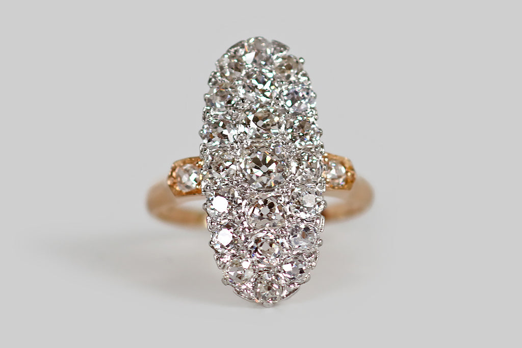 Poor Mouchette | Curated Antique Jewelry, Vintage Jewelry & Engagement Rings | An elegant, low-profile, Edwardian era cluster ring, modeled in 14k rose gold and platinum, whose long oval face is encrusted with 21 chunky, near-colorless, old mine cut diamonds (about 2.55 carats, total). These soulful old diamonds are white and very clean (G/H, VS-SI).