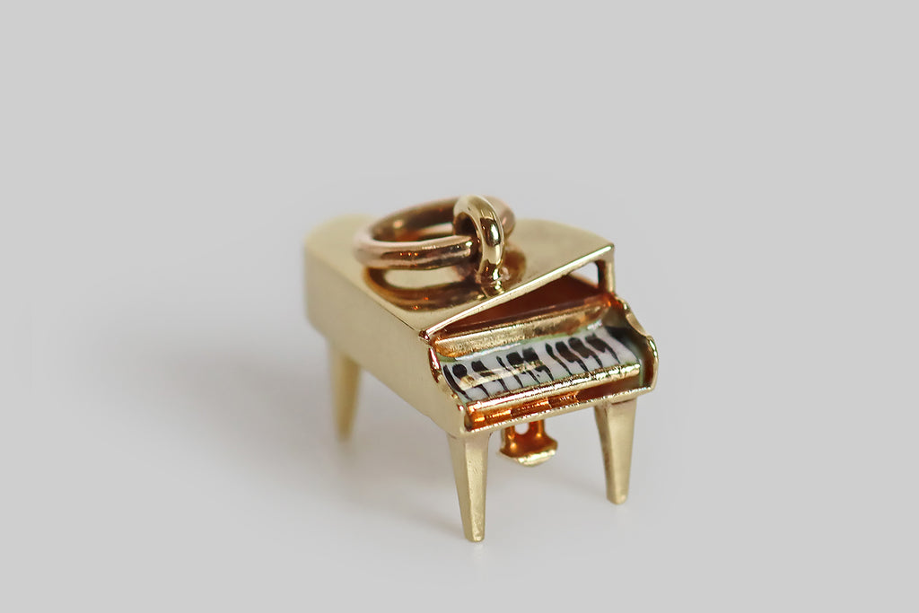 Antique Jewelry Portland, Vintage Jewelry Portland , Antique Engagement Rings | Poor Mouchette | A dainty vintage charm, modeled as a grand piano in 14k yellow gold, by the Newark jewelers Sloan & Co. This little piano is beautifully made, in three dimensions— its tiny black and white keys were hand-painted in black and white enamel, with a hair-fine brush. This old charm is a rarity. It would make a wonderful talisman for a pianist, a music student, or any music lover!