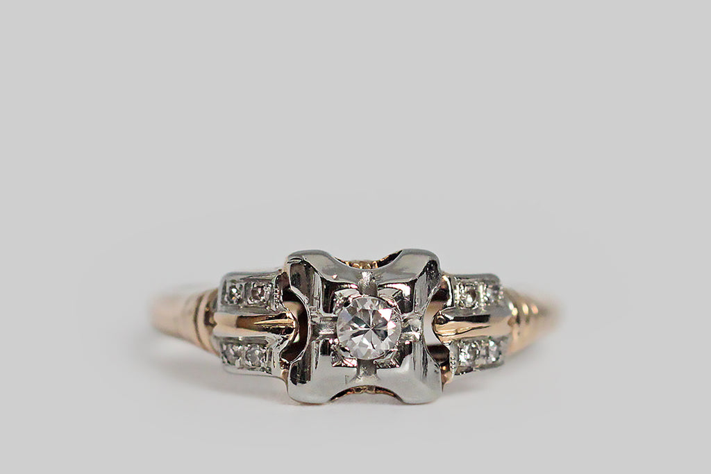 A charming, 1940s engagement ring, modeled in white and rosy-yellow 14k gold. This old darling features a transitional cut diamond, which is bead-set into the ring's unique, x-shaped face. Two pairs of diamond-studded epaulettes add interest to the ring's shoulders, along with a subtle ribbed detail. The half-round shank tapers toward the base. Marked 14k for purity.