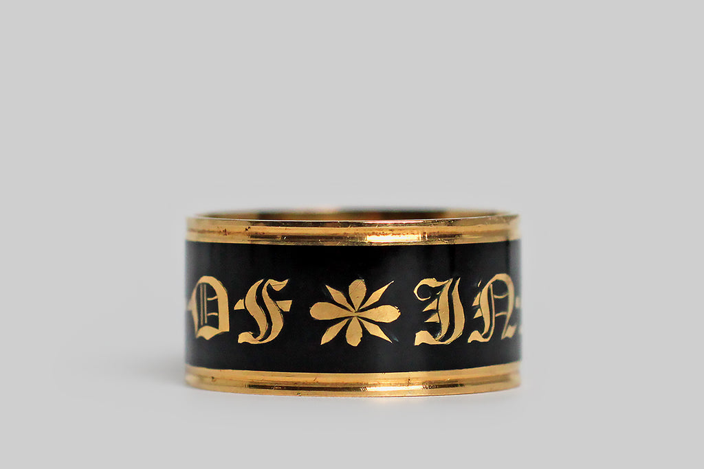 Poor Mouchette | Curated Antique Jewelry, Vintage Jewelry & Engagement Rings | Portland, Oregon | A beautiful, Georgian-era, wide band ring, modeled in 18k gold and decorated with black enamel. This broad, flat mourning band was made in memory of George Moody, and it is dated for the year 1818. This has a very subtle ribbed detail, at the lip, but its striking, clean lines are otherwise uninterrupted. The band's smooth, enameled face reads “in memory of,” in bold gothic script.