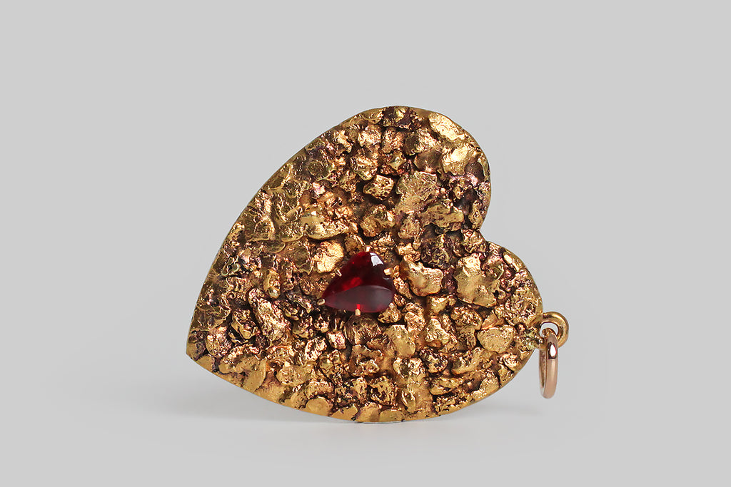 Poor Mouchette | Curated Antique Jewelry, Vintage Jewelry & Engagement Rings | Portland, Oregon | An extra large, Victorian-era heart pendant, covered edge-to-edge in natural gold nuggets. These gold nuggets have a rich, high, gold color, and fascinating organic textures. A sanguine, heart-shaped, garnet doublet rests amid these nuggets, in six, claw-like prongs. The heart's backplate is pierced from 14k gold sheet