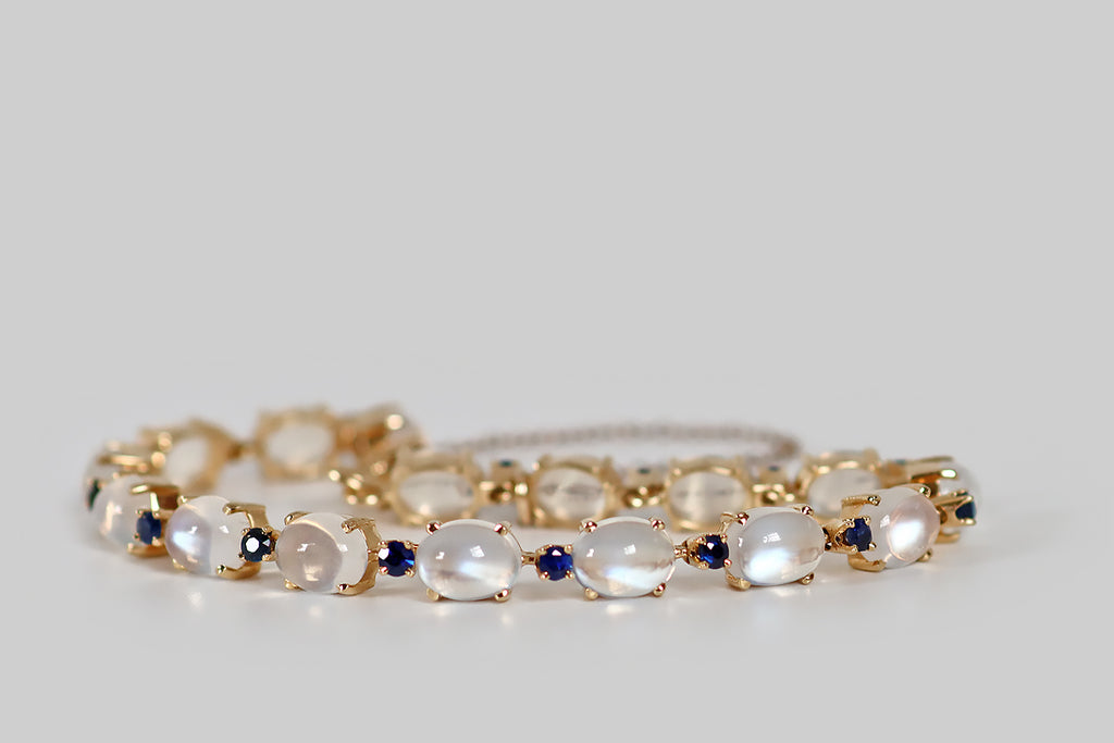 Antique Jewelry Portland, Vintage Jewelry Portland , Antique Engagement Rings | Poor Mouchette | A beautiful retro era bracelet, modeled in 14k yellow gold, and set with sixteen, oval, blue-flash moonstones. These moonstones are very fine, and their strong blue-white adularescence shifts with movement.