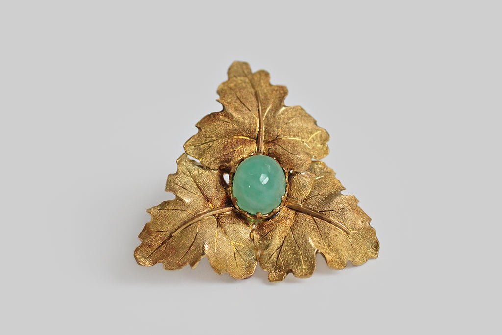 A glamorous vintage brooch by the beloved Italian design house Buccellati, modeled as three naturalistic maple leaves fanning out around a prong-set, high-dome, natural, jadeite cabochon. The maple leaves are highly dimensional, gracefully arched, and are decorated with Buccellati's signature hand-engraving techniques. 