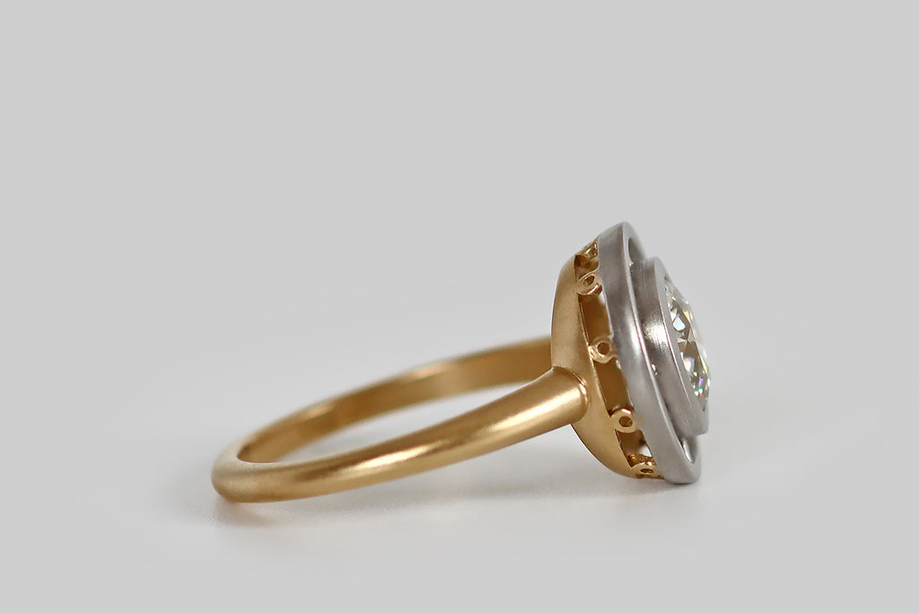 Poor Mouchette | Curated Antique Jewelry, Vintage Jewelry & Engagement Rings | Portland, Oregon | A newly hand-made engagement ring, whose gem in an antique, 1.25 carat Old European cut diamond (I/J, VS1). This brilliant old rainbow-maker is held in a smooth bezel, where (thanks to four small spacers) it appears to hover inside a second, larger bezel. Our target style ring face takes its inspiration from the delicate floating bezels of the Edwardian and Belle Epoque eras.