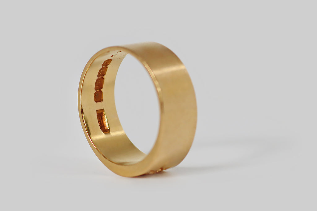 Poor Mouchette | Curated Antique Jewelry, Vintage Jewelry & Engagement Rings | Portland, Oregon | A bold, Edwardian-era, cigar band ring, whose face is set with a single, sparkling, old mine cut diamond. This band is substantial, with a broad, flat profile. Its antique diamond (I/J, SI1) rests in a beautiful, hand-cut, star-shaped seat. The rays of this star are long, deeply-graved, and they terminate in fine