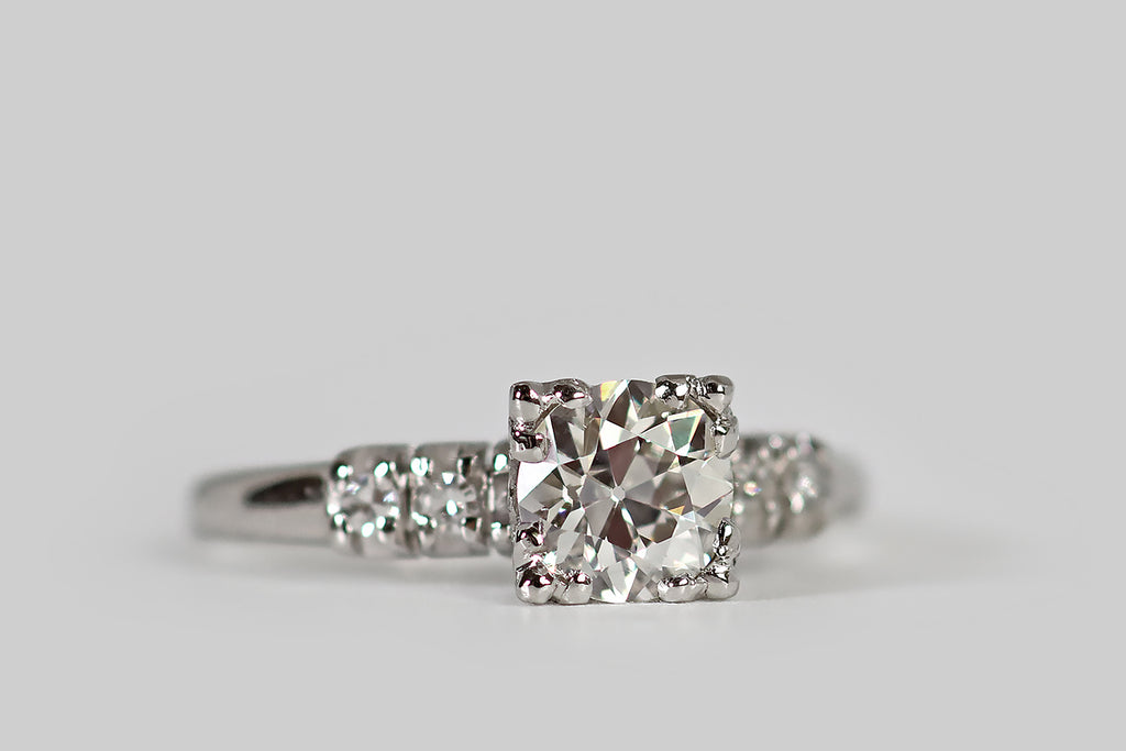 Antique Jewelry Portland, Vintage Jewelry Portland , Antique Engagement Rings | Poor Mouchette | A classic late Art Deco engagement ring, modeled in platinum, whose primary gem is a .87 carat old European cut diamond (G-H/VS1). This vibrant, hand cut diamond is mounted in a decoratively-pierced basket, where four, three-lobed, clover-like prongs hold it securely in place.