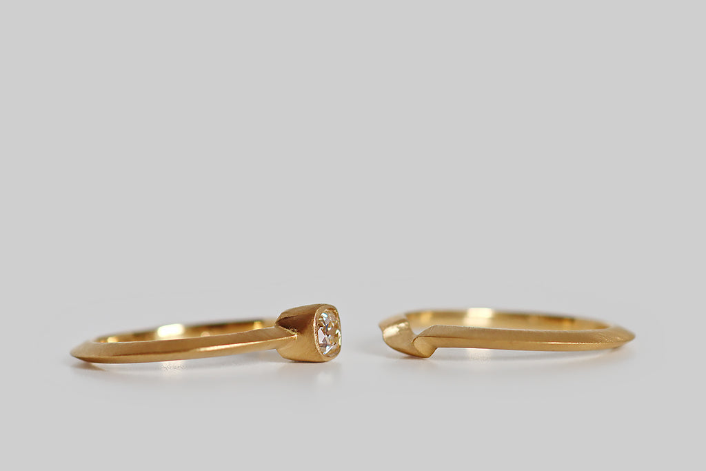 Poor Mouchette | Curated Antique Jewelry, Vintage Jewelry & Engagement Rings | Portland, Oregon | A low-profile, solitaire wedding set, modeled in 18k yellow gold, that features an antique .39 carat peruzzi cut diamond (J/VS). This charming antique diamond rests in a smooth bezel that is centered on the ring's dramatic knife-wire shank. The engagement ring is paired with a matching shadow band, that nests with it, perfectly following its lines. This set is both backward and forward looking.
