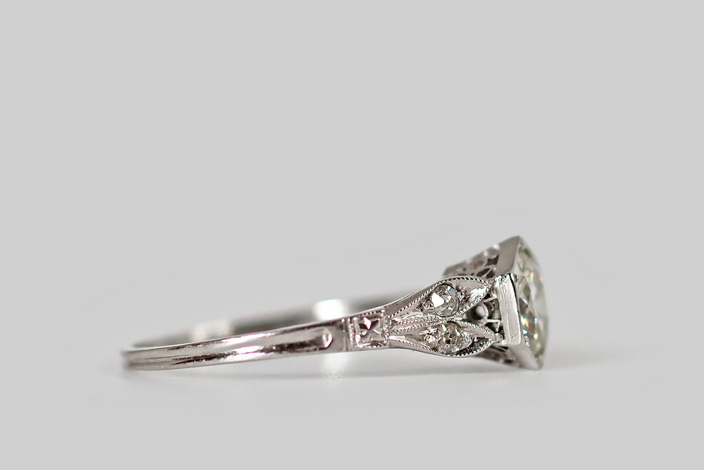 Antique Jewelry Portland, Vintage Jewelry Portland , Antique Engagement Rings | Poor Mouchette | An elegant, Art Deco era solitaire, modeled in platinum, whose primary gem is a very sparkly, white-facing, 3/4 carat old European cut diamond. This wonderful hand-cut diamond is seated in a low-profile, milgrained, hexagonal bezel, where it is held in place by six beaded prongs. It is flanked by the long pairs of leaves that comprise the ring's cathedral shoulders