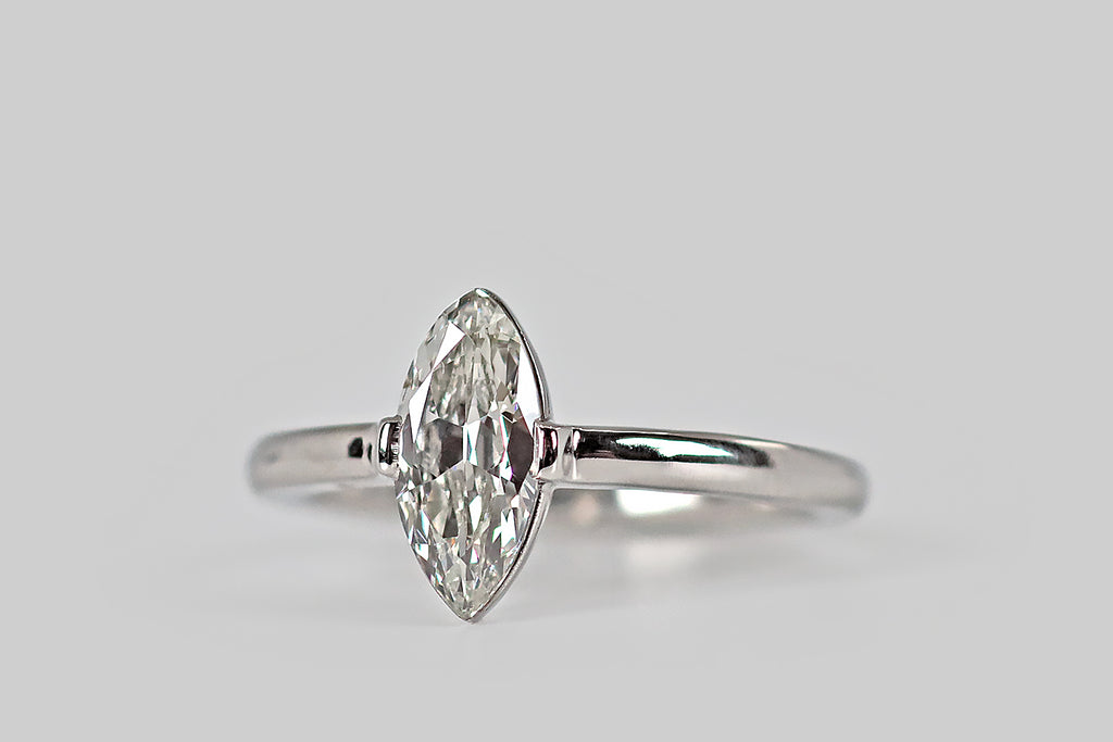 Antique Jewelry Portland, Vintage Jewelry Portland , Antique Engagement Rings | Poor Mouchette | Crisp and ethereal, an antique, .95 carat marquise-cut diamond (G/H, VS2) rests atop a polished, slim-line, platinum basket. This basket is bezel-like, with an extra-fine edge that allows the diamond to "float" on the hand. A pair of broad, low-profile, tab-style prongs hold the diamond securely at the east and west.