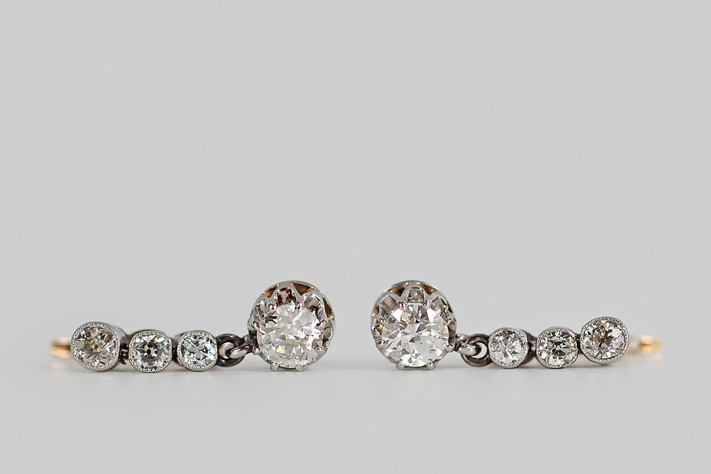Poor Mouchette | Curated Antique Jewelry, Vintage Jewelry & Engagement Rings | Portland, Oregon | A wonderful pair of Art Deco era earrings, modeled in 14k yellow and white gold, each made-up of a series of three, bezel-set, old mine cute diamonds, and a larger, old European cut diamond drop. Our diamond trios are arranged in vertical lines, where they are held in hand-fabricated, white gold bezels— below this "diamond line