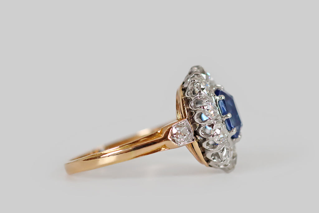 Poor Mouchette | Curated Antique Jewelry, Vintage Jewelry & Engagement Rings | A striking Edwardian-era cluster ring, modeled in 18k gold and platinum, whose primary gem is a bright, highly-saturated, 1.9 carat, no-heat Ceylon sapphire (GIA certified). This vibrant, old cushion-cut sapphire is mounted in ten prongs, and surrounded by a halo of ten, near-colorless, old European cut diamonds (H/I, SI).