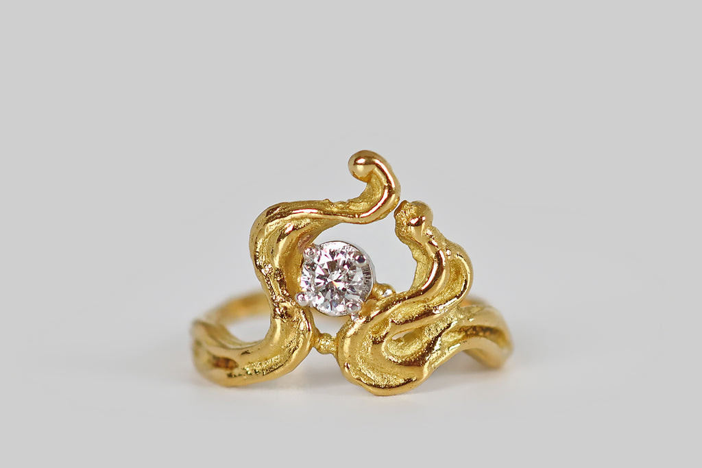 Antique Jewelry Portland, Vintage Jewelry Portland , Antique Engagement Rings | Poor Mouchette | A striking, mid-twentieth-century ring, modeled in 18k yellow gold, whose irregular, curling form is suggestive of flames. These graceful, meandrous forms bend, curl, and rise to create the ring's sculptural face. A sparkling, round brilliant cut diamond rests off-center, in a four prong basket, where these curvaceous, flame-like lines lean together. We love this ring for its organic movement and its artfully 
