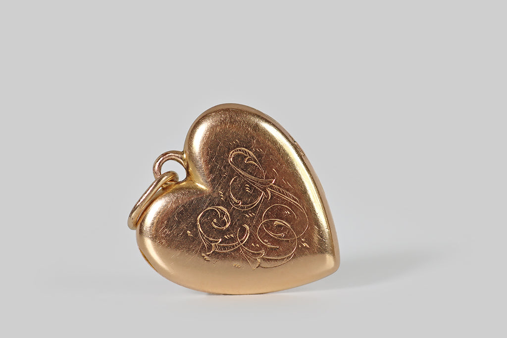 Poor Mouchette | Curated Antique Jewelry, Vintage Jewelry & Engagement Rings | Portland, Oregon | A Victorian-era heart-shaped locket, modeled in 14k rosy yellow gold, whose face is decorated with a beautiful, hand-graved, gem-set trefoil. This stemmed trefoil is inverted, so its central leaf points toward the point of the heart. It is bead-set with three, small old-cut gems— a diamond, a ruby, and a sapphire— to symbolize the French tricolour flag.