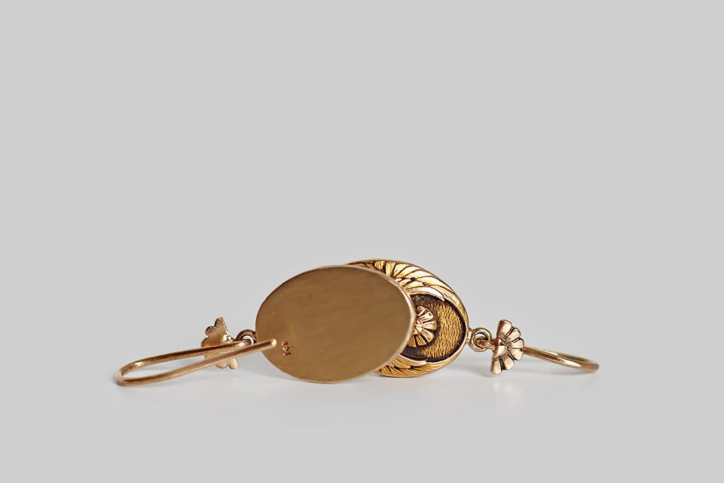 Poor Mouchette | Curated Antique Jewelry, Vintage Jewelry & Engagement Rings | A seriously charming pair of Art Nouveau Egyptian revival earrings, whose oval drops feature a highly detailed and beautifully textured carving of a scarab beetle with open wings. These lovely scarabs hang below a pair of hand-fabricated earwires that are decorated with a motif that repeats the rising sun shape