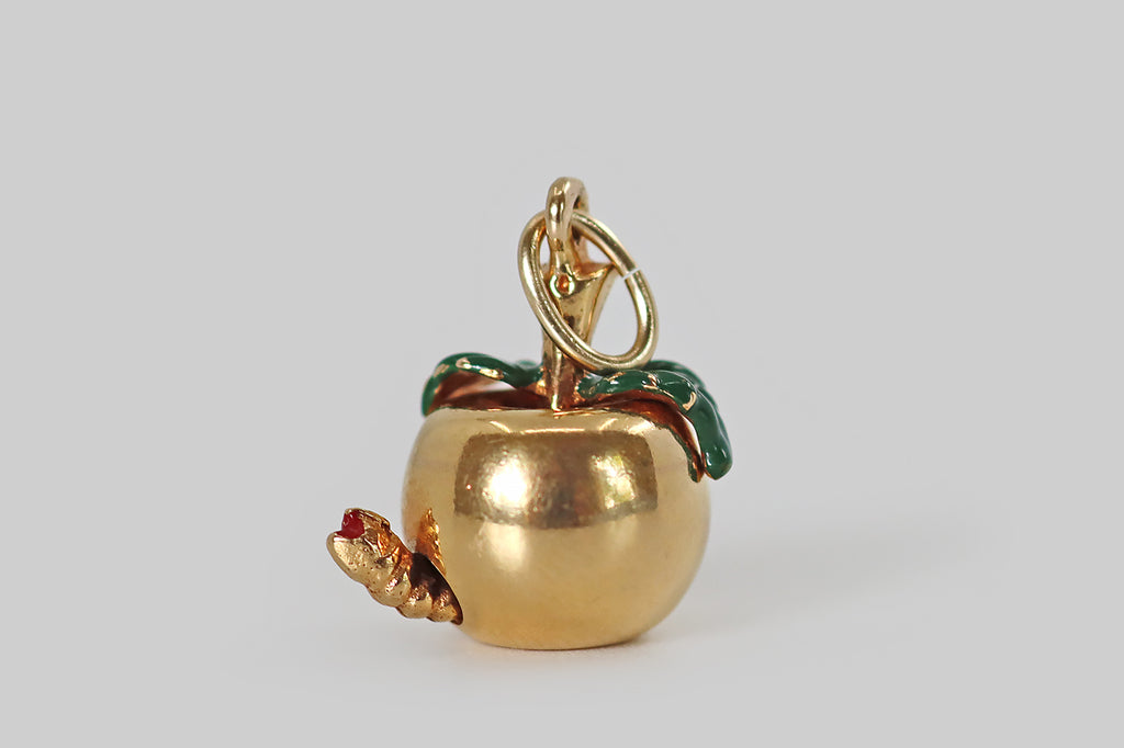 Antique Jewelry Portland, Vintage Jewelry Portland , Antique Engagement Rings | Poor Mouchette | A wonderful vintage enameled charm,&nbsp;modeled in 14k yellow gold, that is made in the form of a beautiful apple, with a naughty worm at its base! This miniature apple has a smooth, buttery, time-won sheen. Its green enameled leaves drape over its shoulders. The little worm at the base of the apple eats its way through the fruit