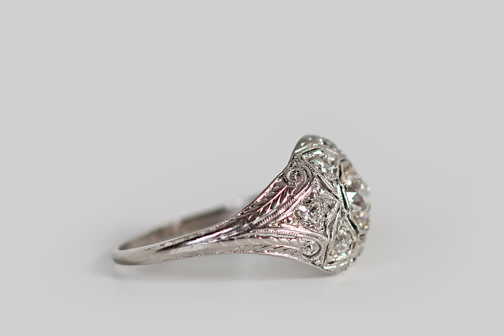 Poor Mouchette | Curated Antique Jewelry, Vintage Jewelry & Engagement Rings | Portland, Oregon | An early Art Deco era, diamond cluster ring, with a low, domed profile, whose primary gem is a .46 carat old European cut diamond. This primary diamond is bead-set into an octagonal seat, where it is surrounded by a bevy of old cut supporters. Four diamonds, in lobe-shaped seats, flank the primary stone, creating the impression of a quatrefoil.