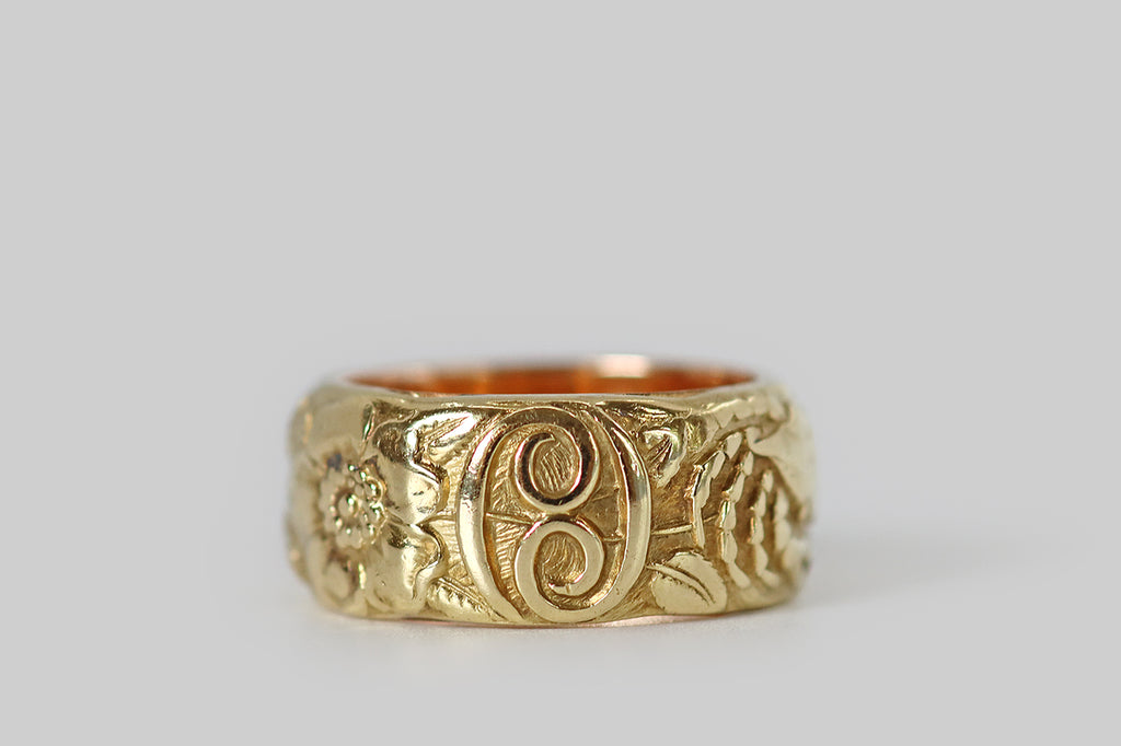 Poor Mouchette | Curated Antique Jewelry, Vintage Jewelry & Engagement Rings | Portland, Oregon |A rare and wonderful Art Nouveau era wide band ring, modeled in 14k yellow gold, whose face is decorated with a series of images (in relief) that represent the astrological sign Cancer. Among these beautifully carved figures is a gentle crab, a pair of wild roses, and Cancer's astrological glyph. The carving here is masterful