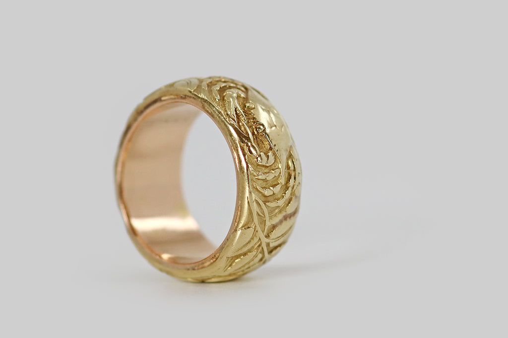 Poor Mouchette | Curated Antique Jewelry, Vintage Jewelry & Engagement Rings | Portland, Oregon |A rare and wonderful Art Nouveau era wide band ring, modeled in 14k yellow gold, whose face is decorated with a series of images (in relief) that represent the astrological sign Cancer. Among these beautifully carved figures is a gentle crab, a pair of wild roses, and Cancer's astrological glyph. The carving here is masterful