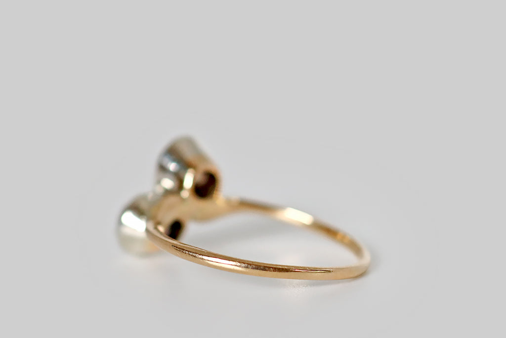 Poor Mouchette | Curated Antique Jewelry, Vintage Jewelry & Engagement Rings | Portland, Oregon | An Art Nouveau era, toi et moi engagement ring, modeled in 14k yellow gold and platinum, whose gems are a pair of soulful, old European cut diamonds (approx 1.25 carats total weight). These OEC diamonds are held in platinum bezels, where they are mounted on the diagonal, atop the ring's curvaceous, whisper-weight shank. Though they are both Old European cuts, the faceting patterns of these two diamonds 