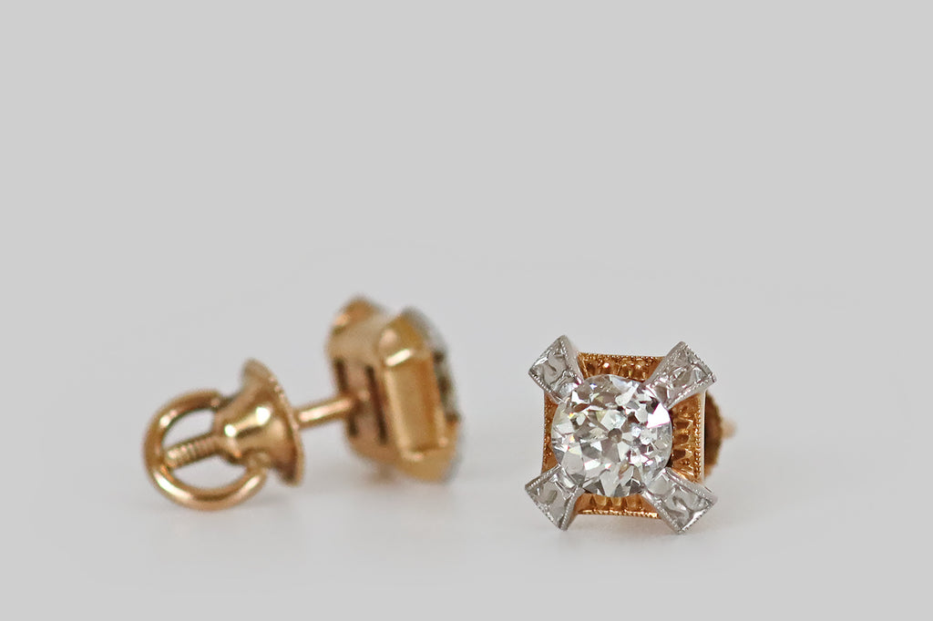Poor Mouchette | Curated Antique Jewelry, Vintage Jewelry & Engagement Rings | Portland, Oregon | A pair of Art Deco era diamond stud earrings, modeled in 14k gold and platinum, each featuring a chunky, old European cut diamond. These antique diamonds are each held in four, stylized, platinum, tab-style prongs that stand off the earrings' yellow gold base, creating the impression of an "X" or a Maltese cross.