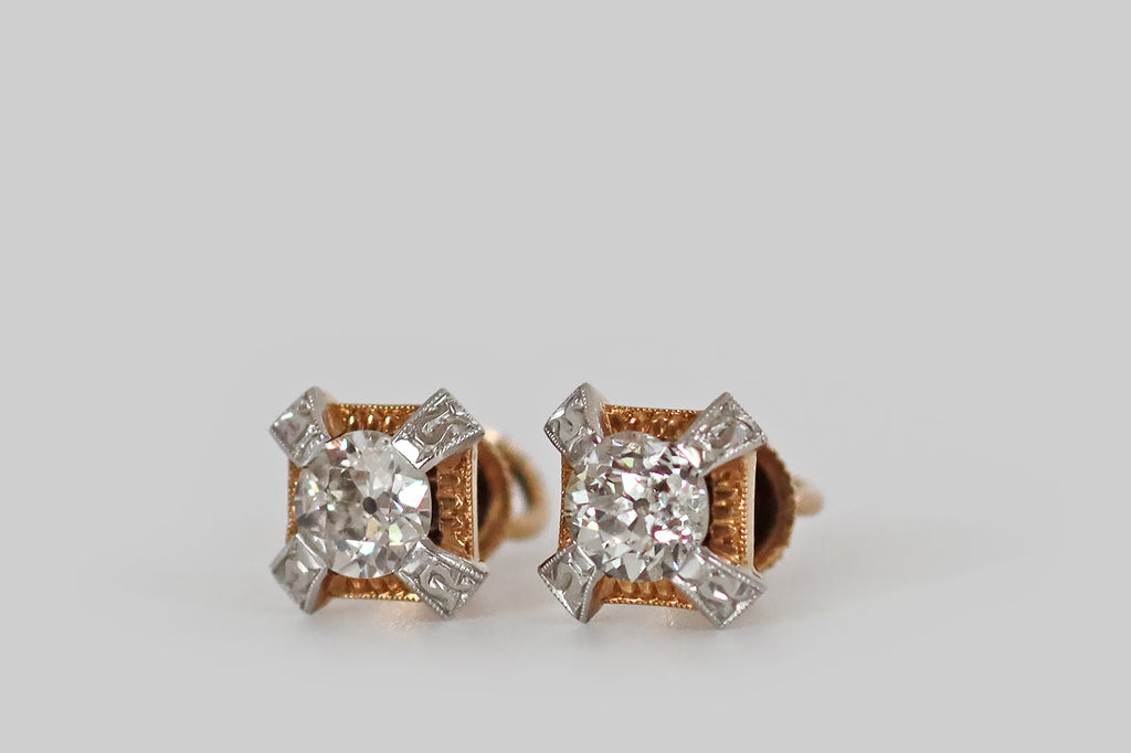 Poor Mouchette | Curated Antique Jewelry, Vintage Jewelry & Engagement Rings | Portland, Oregon | A pair of Art Deco era diamond stud earrings, modeled in 14k gold and platinum, each featuring a chunky, old European cut diamond. These antique diamonds are each held in four, stylized, platinum, tab-style prongs that stand off the earrings' yellow gold base, creating the impression of an "X" or a Maltese cross.