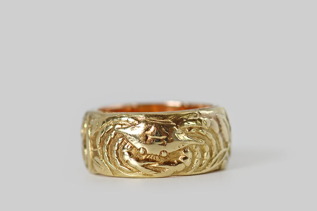 Poor Mouchette | Curated Antique Jewelry, Vintage Jewelry & Engagement Rings | Portland, Oregon |A rare and wonderful Art Nouveau era wide band ring, modeled in 14k yellow gold, whose face is decorated with a series of images (in relief) that represent the astrological sign Cancer. Among these beautifully carved figures is a gentle crab, a pair of wild roses, and Cancer's astrological glyph. The carving here is masterful