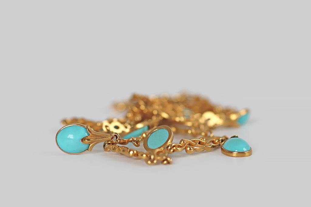 Poor Mouchette | Curated Antique Jewelry, Vintage Jewelry & Engagement Rings | An especially lovely, Art Nouveau era fringe necklace, modeled in 14k yellow gold, whose seven drops are set with vibrant, sky-blue, Persian turquoise cabochons. These sweet turquoise berries or buds are crowned with beautifully carved gold calyces.