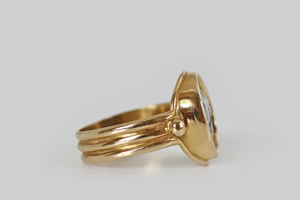 Antique Jewelry Portland, Vintage Jewelry Portland , Antique Engagement Rings | Poor Mouchette | A late-vintage monete style ring, modeled in 14k yellow gold, whose coin features the goddess Athena, wearing a Corinthian helmet. This silver coin is held in a smooth bezel, where it is flanked by a pair of large, granulated beads. The ring's gallery is fashioned with a rolled lip. Its low-profile shank is broad and reeded. Athena is the Greek goddess of wisdom and strategic warfare.