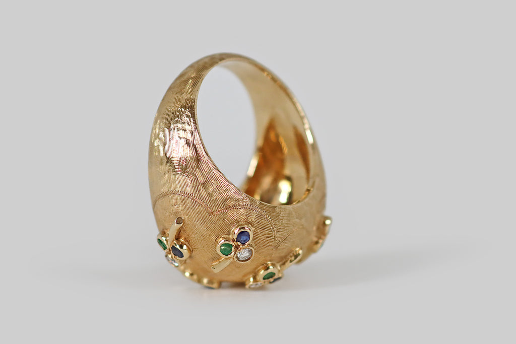 Poor Mouchette | Curated Antique Jewelry, Vintage Jewelry & Engagement Rings | Portland, Oregon | A whimsical, mid-twentieth-century, domed, bombe ring, modeled in 14k yellow gold, whose plump form is decorated with applied, gem-set clovers! These seven three-leaf clovers are strewn across the ring face in a charming, naturalistic manner, as if they were tossed into the air, and landed (here and there) on its textured surface.
