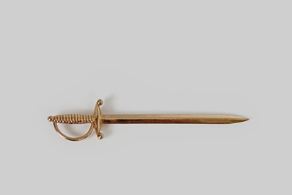 Poor Mouchette | Curated Antique Jewelry, Vintage Jewelry & Engagement Rings | Portland, Oregon | A very cool, true-to-scale cocktail sword, modeled in 18k yellow gold, with a ribbed handle and a beveled, high-polish blade. This solid gold rapier is sharp enough to spear olives, and it hangs beautifully-askew from a bolt ring or dog clip when it's off-duty! 