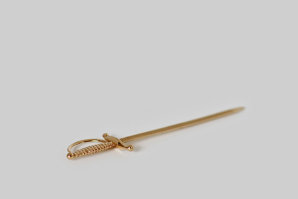 Poor Mouchette | Curated Antique Jewelry, Vintage Jewelry & Engagement Rings | Portland, Oregon | A very cool, true-to-scale cocktail sword, modeled in 18k yellow gold, with a ribbed handle and a beveled, high-polish blade. This solid gold rapier is sharp enough to spear olives, and it hangs beautifully-askew from a bolt ring or dog clip when it's off-duty! 