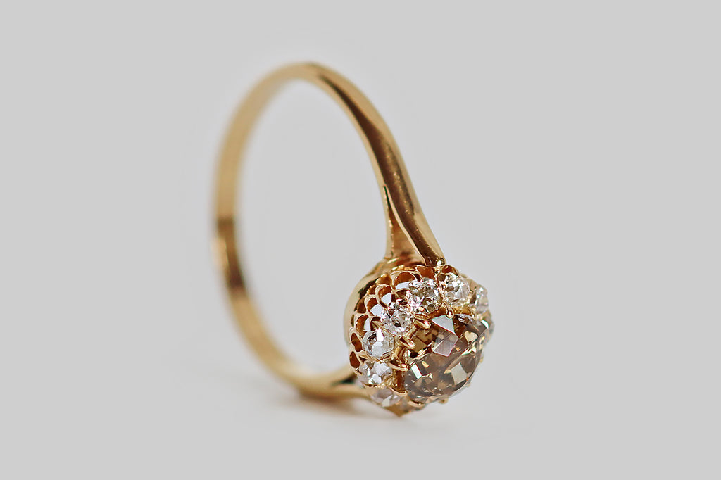 Poor Mouchette | Curated Antique Jewelry, Vintage Jewelry & Engagement Rings | A striking Victorian-era halo ring, modeled in 18k yellow gold, whose primary gem is a fancy-brown old mine cut diamond (.69 carats). This diamond is a rich, neutral, golden-brown color that might be described as whiskey, or cognac. It is chunky, with a small, irregular table and steep crown facets