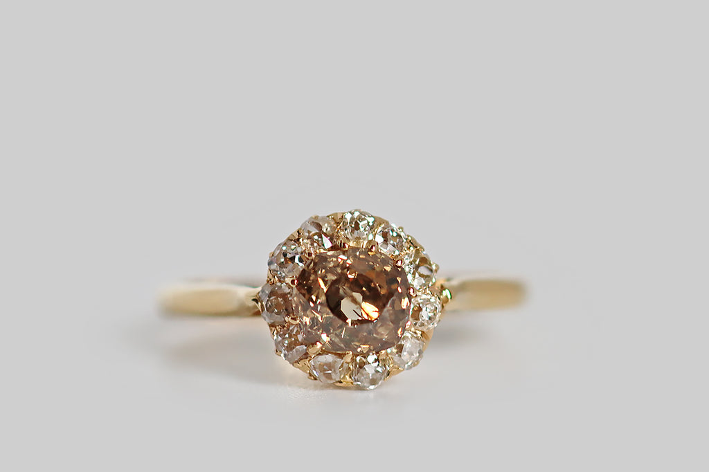 Poor Mouchette | Curated Antique Jewelry, Vintage Jewelry & Engagement Rings | A striking Victorian-era halo ring, modeled in 18k yellow gold, whose primary gem is a fancy-brown old mine cut diamond (.69 carats). This diamond is a rich, neutral, golden-brown color that might be described as whiskey, or cognac. It is chunky, with a small, irregular table and steep crown facets