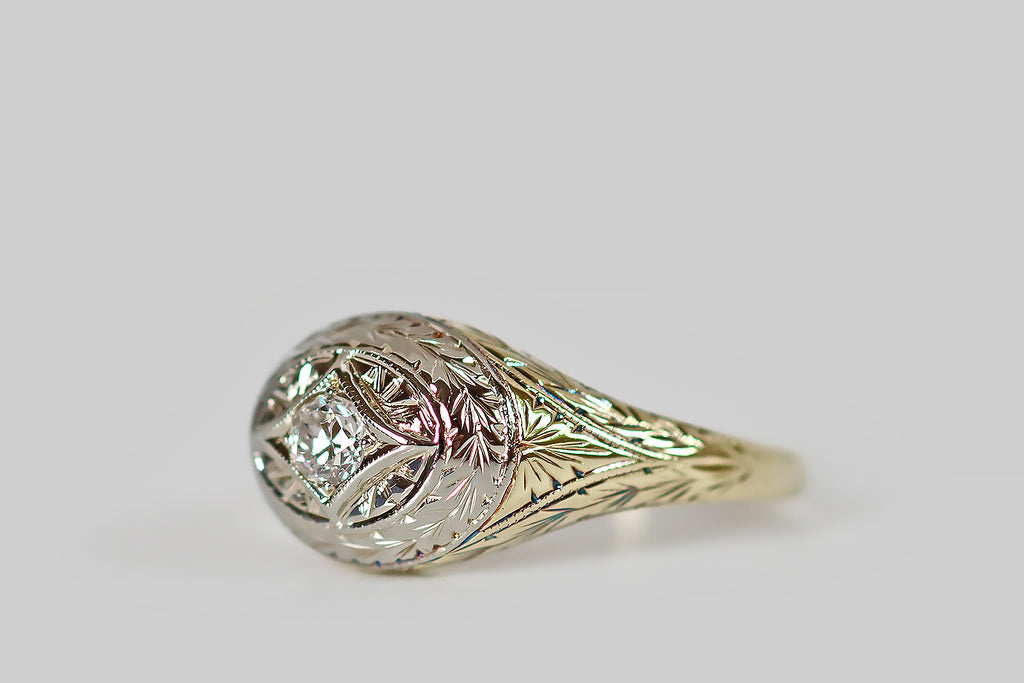 Poor Mouchette | Curated Antique Jewelry, Vintage Jewelry & Engagement Rings | Portland, Oregon | An elegant Edwardian era ring, modeled in 14k gold and platinum, whose east/west-oriented, oval face features a prominent, four-pointed star. This star-shaped seat holds a glittering old European cut diamond— engraved rays surround the diamond-set star, which is surmounted by an engraved, wreath-like, wheat-pattern border.