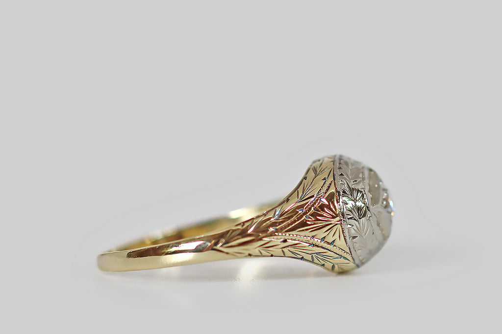 Poor Mouchette | Curated Antique Jewelry, Vintage Jewelry & Engagement Rings | Portland, Oregon | An elegant Edwardian era ring, modeled in 14k gold and platinum, whose east/west-oriented, oval face features a prominent, four-pointed star. This star-shaped seat holds a glittering old European cut diamond— engraved rays surround the diamond-set star, which is surmounted by an engraved, wreath-like, wheat-pattern border.