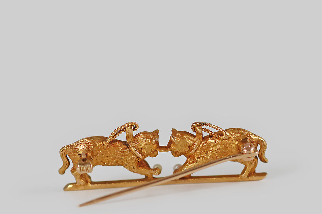 Antique Jewelry Portland, Vintage Jewelry Portland , Antique Engagement Rings | Poor Mouchette | A charming Edwardian-era novelty brooch, modeled substantially in 14k yellow gold, which depicts a pair of kitties at play! These sweet cats are realistically rendered in three dimensions, with beautifully-textured fur details, and emerald cabochon eyes; each cat wears a little collar and a twisted wire leash. Our feline friends are nearly symmetrical