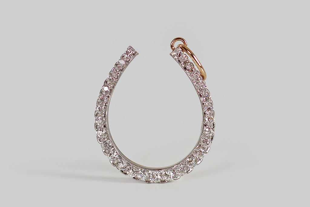 Poor Mouchette | Curated Antique Jewelry, Vintage Jewelry & Engagement Rings | Portland, Oregon | A striking, Edwardian era horseshoe pendant, modeled in 14k gold and platinum, set with twenty-nine sparkling, old European cut diamonds (G/H, VS1-SI1). These charming hand-cut diamonds are set into the platinum face of our horseshoe, using a combination of beads and modified prongs— they cover its surface, edge-to-edge. The diamonds graduate somewhat in size, the largest sitting at the base of the u-shape.