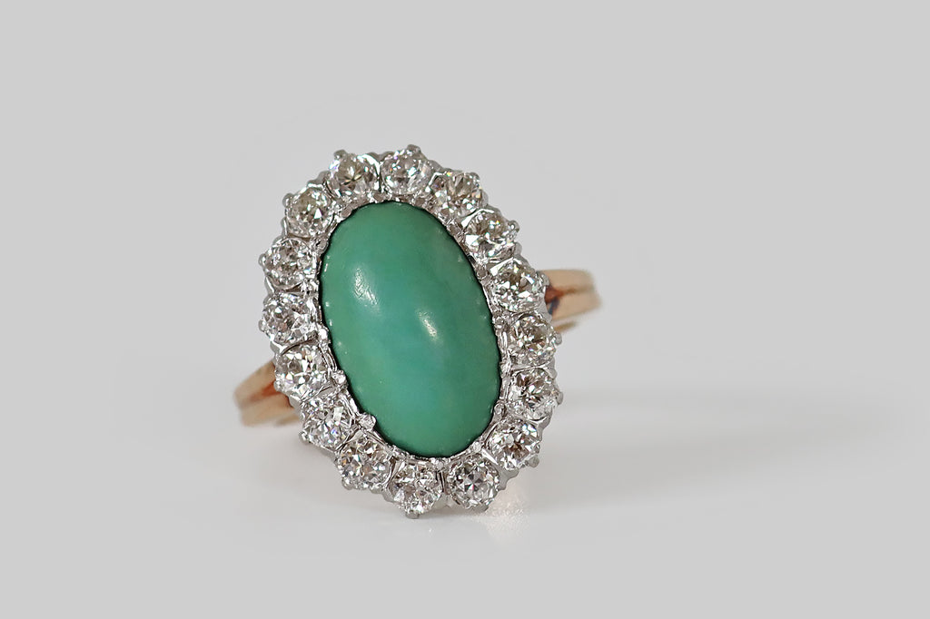 Poor Mouchette | Curated Antique Jewelry, Vintage Jewelry & Engagement Rings | Portland, Oregon | A low-profile, Edwardian era cluster ring, modeled in 14k rosy yellow gold, whose central, gemstone is an elongated, oval, turquoise cabochon. This beautiful, green-blue turquoise has a silky, time-won lustre. It is encircled by a halo of sixteen, chunky Old European cut diamonds (approx 1.5 carats)— these diamonds are bright and lively (H/I, VS1-SI1), with small tables, steep crown facets, and open culets.