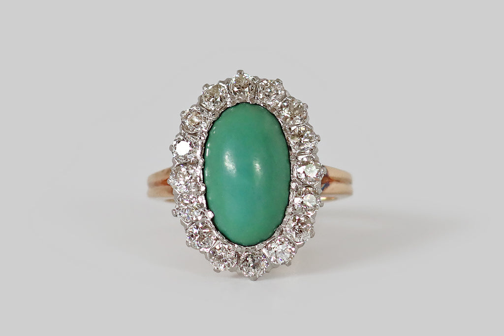 Poor Mouchette | Curated Antique Jewelry, Vintage Jewelry & Engagement Rings | Portland, Oregon | A low-profile, Edwardian era cluster ring, modeled in 14k rosy yellow gold, whose central, gemstone is an elongated, oval, turquoise cabochon. This beautiful, green-blue turquoise has a silky, time-won lustre. It is encircled by a halo of sixteen, chunky Old European cut diamonds (approx 1.5 carats)— these diamonds are bright and lively (H/I, VS1-SI1), with small tables, steep crown facets, and open culets.