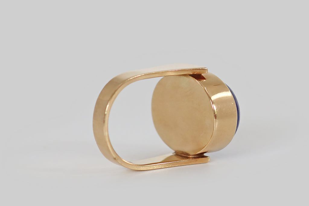 Antique Jewelry Portland, Vintage Jewelry Portland , Antique Engagement Rings | Poor Mouchette | A mid-twentieth-century modernist ring, modeled in 14k yellow gold, by the Danish goldsmith Erik Poul Fenster. This sleek, minimalist design features a large, pyrite-flecked lapis lazuli cabochon, set in a smooth, closed-back bezel. The bezel is held (as if pinched) between the blunt ends of the ring's broad, u-shaped ring shank. 
