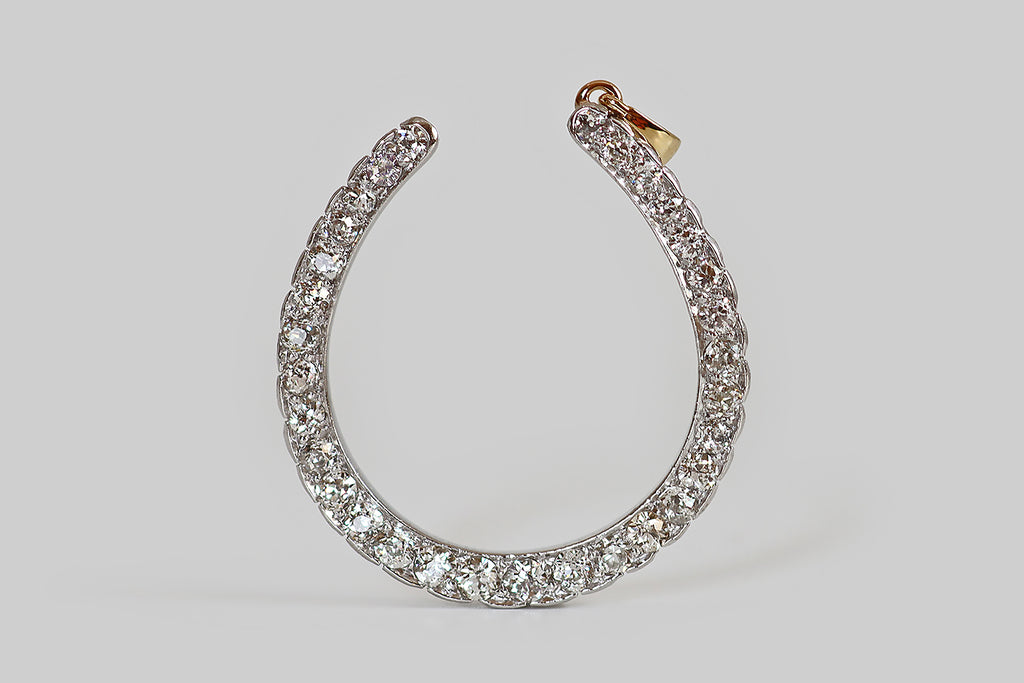 Poor Mouchette | Curated Antique Jewelry, Vintage Jewelry & Engagement Rings | Portland, Oregon | A striking, extra-large, Edwardian era horseshoe pendant, modeled in 15k gold and platinum, set with thirty-two sparkling, old European cut diamonds (H-I, VS1-SI1). These charming hand-cut diamonds are set into the face of our horseshoe, using a combination of beads and modified prongs, where they cover its surface, edge-to-edge.