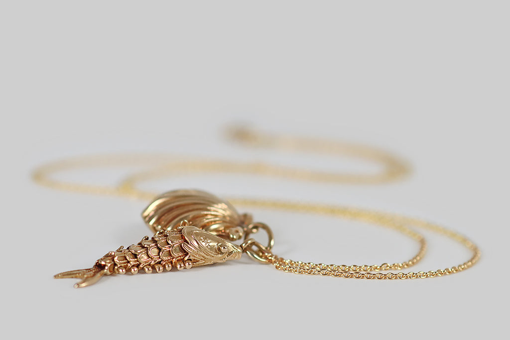 Poor Mouchette | Curated Antique Jewelry, Vintage Jewelry & Engagement Rings | Portland, Oregon | A mid 20th century charm, modeled in 14k yellow gold, that takes the form of a fish with an articulated body. This slinky fellow is fabricated with six, scalloped segments (sssss), between his head and tail— these nested segments (sssss) are fastened together with ball-top rivets.