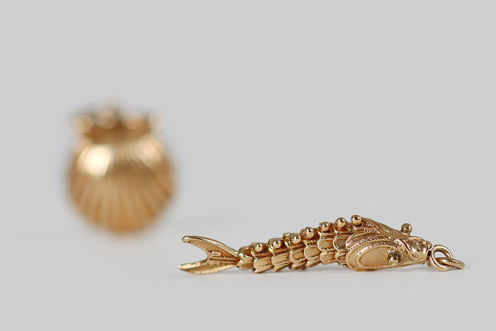 Poor Mouchette | Curated Antique Jewelry, Vintage Jewelry & Engagement Rings | Portland, Oregon | A mid 20th century charm, modeled in 14k yellow gold, that takes the form of a fish with an articulated body. This slinky fellow is fabricated with six, scalloped segments (sssss), between his head and tail— these nested segments (sssss) are fastened together with ball-top rivets. 