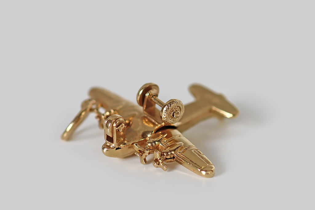 Antique Jewelry Portland, Vintage Jewelry Portland , Antique Engagement Rings | Poor Mouchette | A large, mid-twentieth-century pendant or charm, modeled in 14k yellow gold, as a four-prop passenger airplane. This vintage charm is substantial and highly detailed, with rotating propellers and wheels. It is beautifully made and finished