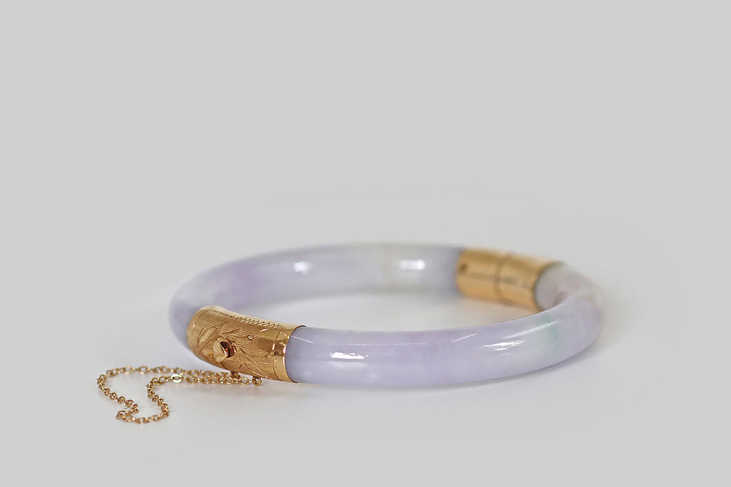 Antique Jewelry Portland, Vintage Jewelry Portland , Antique Engagement Rings | Poor Mouchette | A natural, untreated, lavender jadeite jade bangle, fashioned with an engraved 14k yellow gold hinge and clasp. This jade is a soft and bright lavender color. Its secondary color is cool, muted celadon green, and it is also figured with a single thread of bright green.
