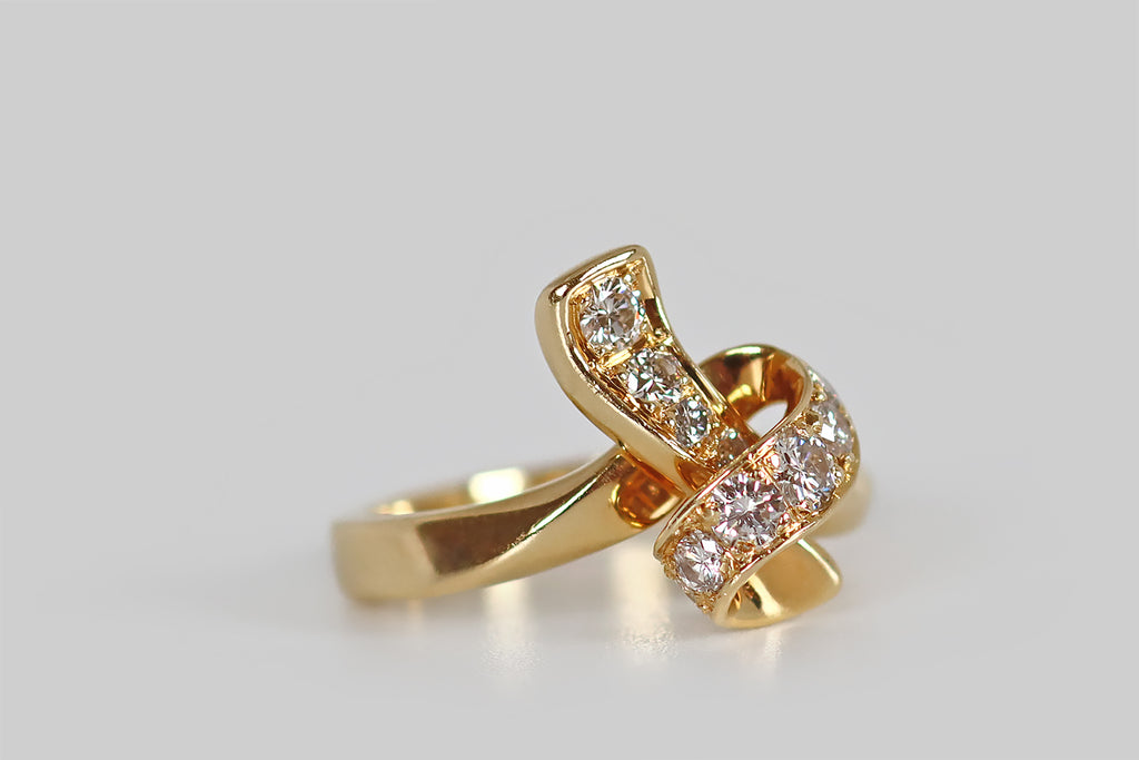 Antique Jewelry Portland, Vintage Jewelry Portland , Antique Engagement Rings | Poor Mouchette | A sculptural, late vintage ring, modeled in 18k yellow gold, that takes the form of a ribbon, tied into a loose knot. This graceful knot is fully three dimensional, with a long tail that lays behind its primary loop. Ten sparkling, round brilliant cut diamonds (F/G, VS) are bead-set into the face of the knot. 