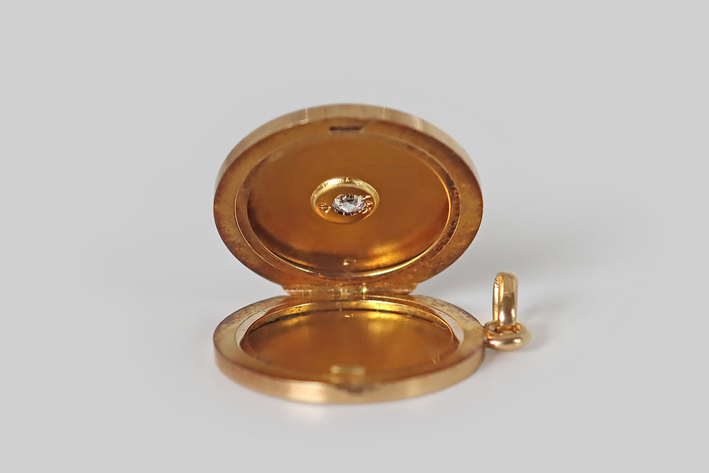 Poor Mouchette | Curated Antique Jewelry, Vintage Jewelry & Engagement Rings | Portland, Oregon |An early Art Deco era locket, modeled in 14k yellow gold, whose decor is a series of engraved, close-set, concentric circles, expanding outward from the locket's central, old European cut diamond. This locket is especially beautiful in movement, when its grooved surface reflects the light in an almost hypnotic manner! It reminds us of an LP, or of a hypnotist's wheel. We love it for this reason