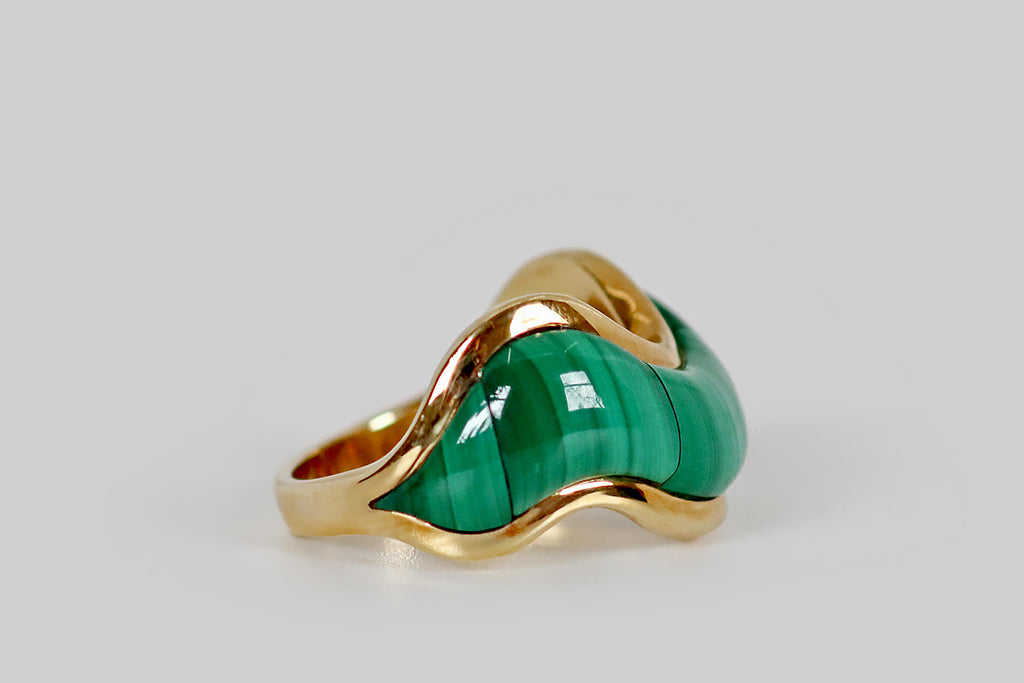 Poor Mouchette | Curated Antique Jewelry, Vintage Jewelry & Engagement Rings | Portland, Oregon | A late vintage ring, modeled in 14k yellow gold, whose curvy, wave-form face is inlaid with three plump malachite cabochons. These carefully cut malachite cabs feature beautiful bright and dark green linear figuring— they appear to be a single swath of striated stone, they fit so seamlessly together! This chubby malachite swath is framed by slender borders of high polished gold. 